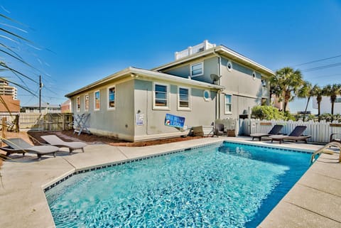 Sparkling private pool framed by palm trees and coastal charm.