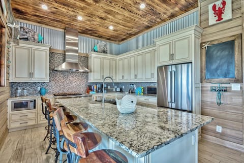 Open kitchen w/ large island, bar stools, and rustic finishes for easy entertaining