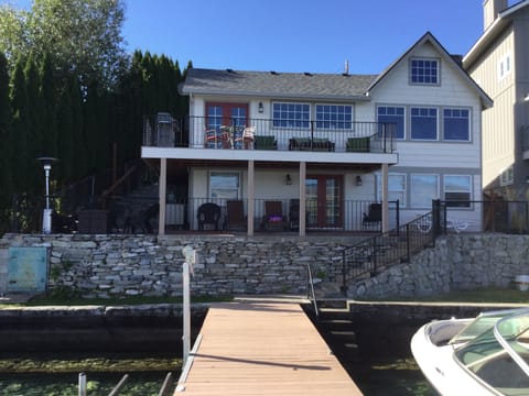 House from the water. Sun and shaded seating. Gas fire pit w/ chairs on the left
