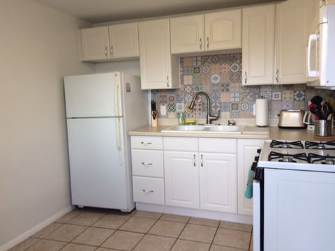 Kitchen, stocked with dishes and cooking utensils.
