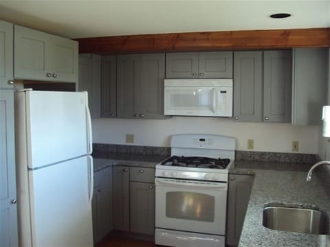 New Kitchen on first floor with lots storage space and granite counter, & table.