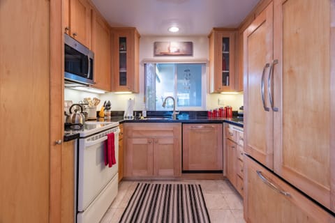 Fully equipped kitchen w/ granite countertop & limestone flooring