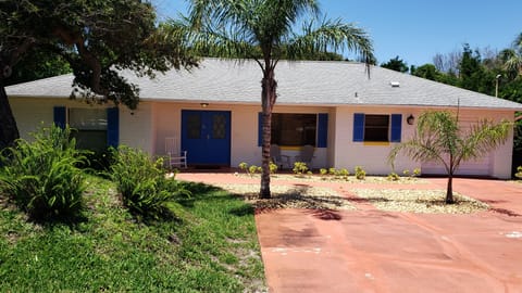 Front of beach house with a rocking chair and 2 Adirondack chairs to chill in.  