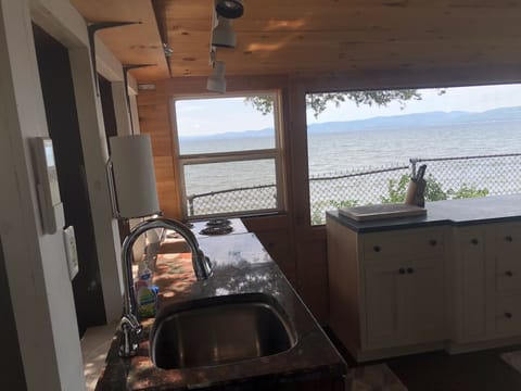 Standing in bunk room looking at 4 burner stove on the end, AC remote on wall