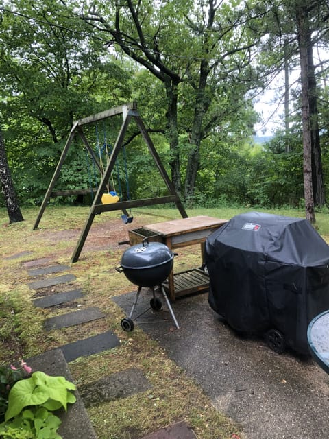 Swing set and grill on patio.