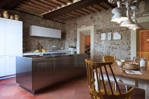The kitchen with stone walls and modern Poliform cabinets 