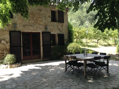 Cottage front with peach orchard on right .