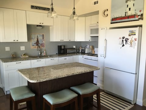 Newly renovated kitchen with granite island that seats four. 