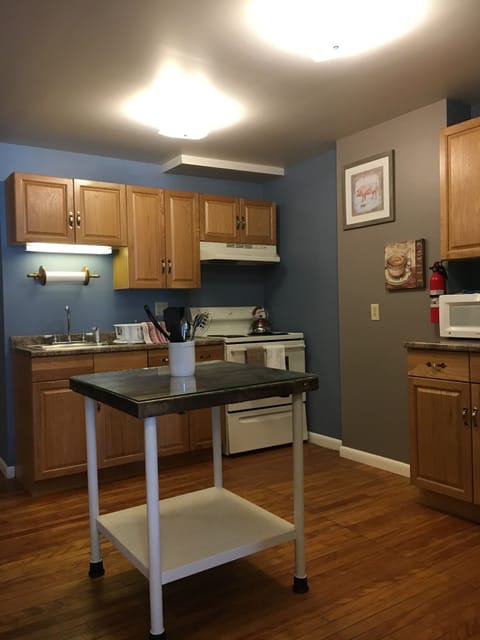 Butcher block, glass-top island in kitchen for food prep.
