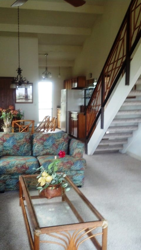 living room to kitchen with stairway access to loft