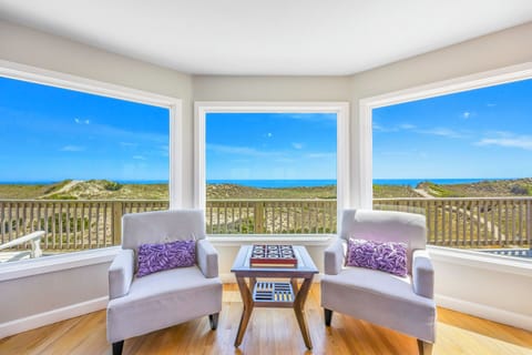 Unwind in your bright corner seating area with panoramic views of rolling dunes and endless blue skies stretching to the horizon.