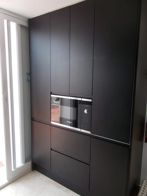 Kitchen pull out larder and bin unit, There is also a new integrated microwave.