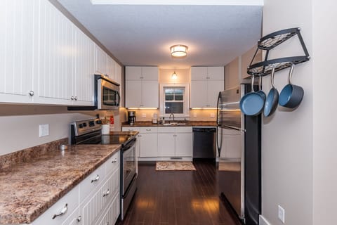 Kitchen is stocked with pots and pans, spices, baking sheets, and more. 