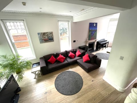 Bright open-plan living room with comfortable seating and period features.