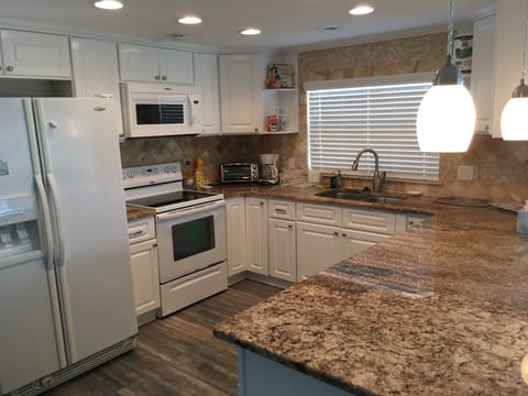 kitchen with granite counters, microwave, coffee maker 