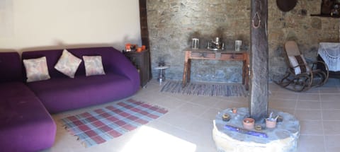lounge with large purple coach and antiques, vintage vases, Hi fi and turntable
