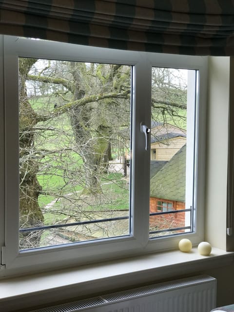 Large window from bedroom looking onto our garden and stables