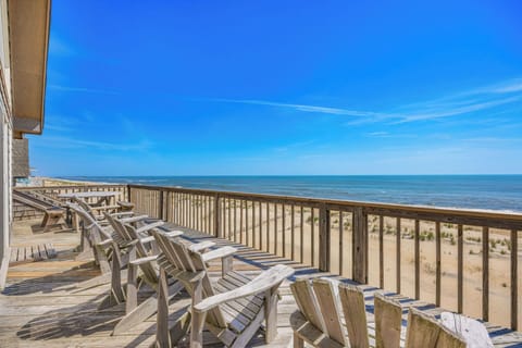 Beachfront deck overlooking sandy shores and calm ocean waters, offering direct access to the sea and expansive coastal views.