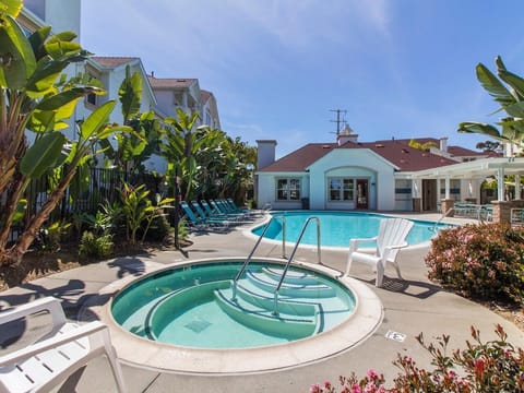 Gated pool and Jacuzzi with lounge chairs, tables, showers and restrooms