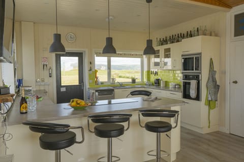 Breakfast bar houses induction hob. 4 Adjustable bar stools for informal dining