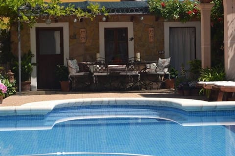 Pérgola junto a la piscina, habitación y baño