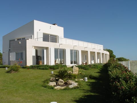Modern white façade with terrace and manicured gardens — Villa Foz, luxury holiday villa in Sesimbra