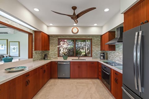 Beach house fully equipped kitchen with natural light and views of the vibrant garden.