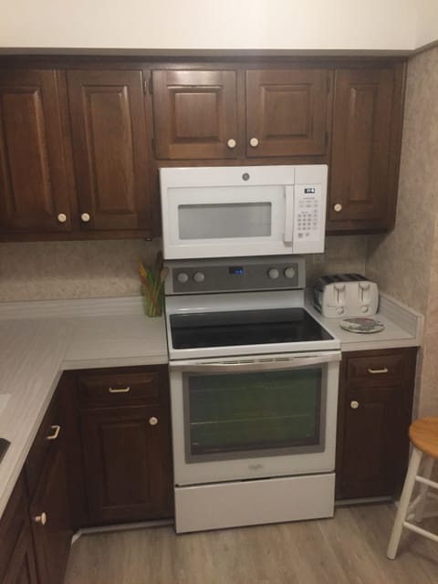 kitchen with updated flooring, glass top range, fridge, DW, microwave