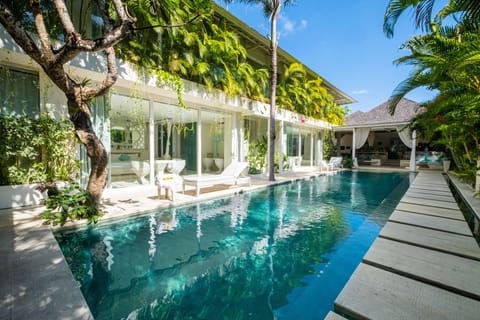 The villa features a pool adjacent to the bedrooms and outdoor lounge area.
