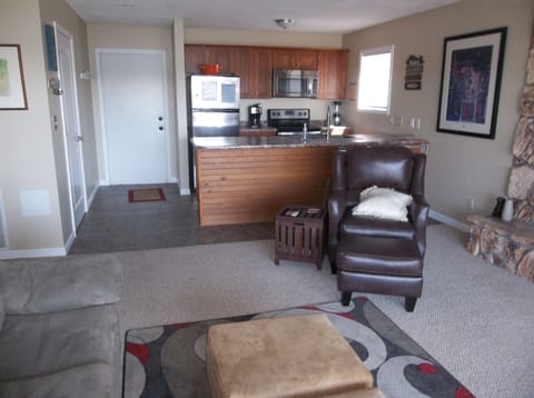 View of kitchen and entry from living room (prior to new wood flooring)