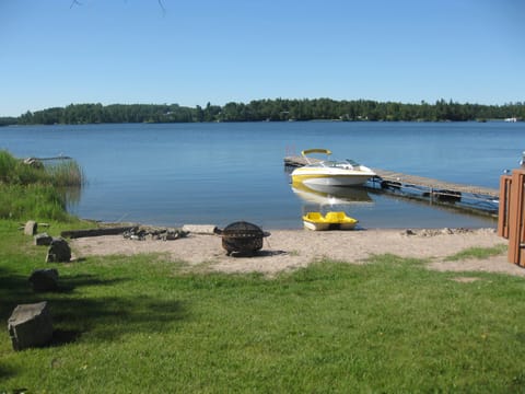 Another view of the beach area showing firepits, dock, and paddle boat.