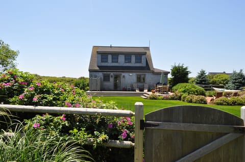 Back of home, deck, outdoor shower, secluded brick patio on right.