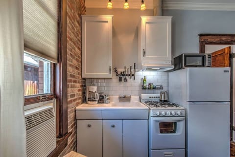 Compact kitchen with full stove, fridge, microwave, and coffee maker, everything you need for cooking at home or brewing your morning coffee.