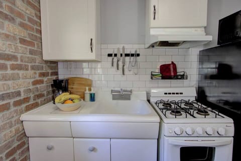 Compact kitchen with full stove, fridge, microwave, and coffee maker, everything you need for cooking at home or brewing your morning coffee.