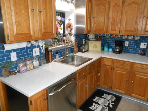 Quartz counter tops and blue glass tile back splash compliment Oak cabinets 