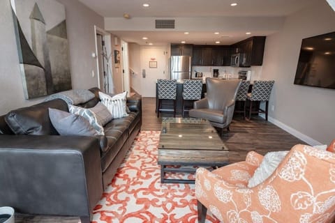 Looking across the living area with the kitchen beyond.  Giant Smart TV w Cable