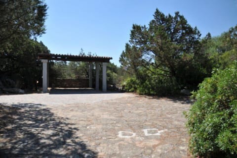 Entrance with large parking area including several covered spaces.