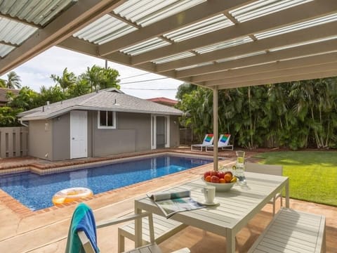 The backyard features a sparkling pool and the charming guest cottage.