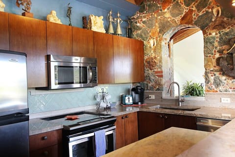 Kitchen features granite countertops, tile backsplash, large stainless sink 