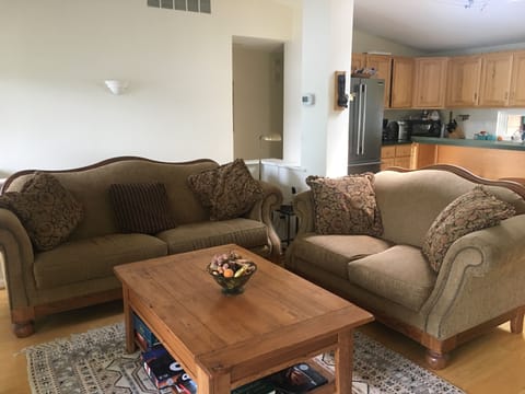 Open plan living area with kitchen and breakfast bar to rear