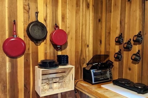 The kitchen has toaster oven, stovetop burners, coffee maker, and basic cooking utensils. 