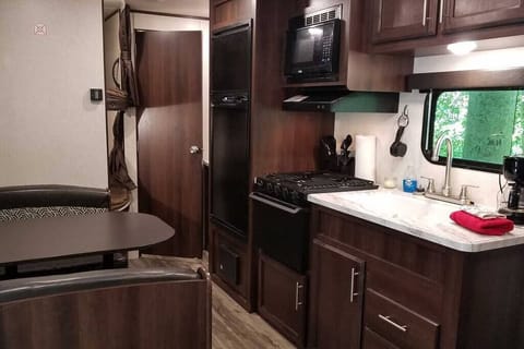 Kitchen area with appliances - refrigerator, freezer, gas range, oven and microwave. 