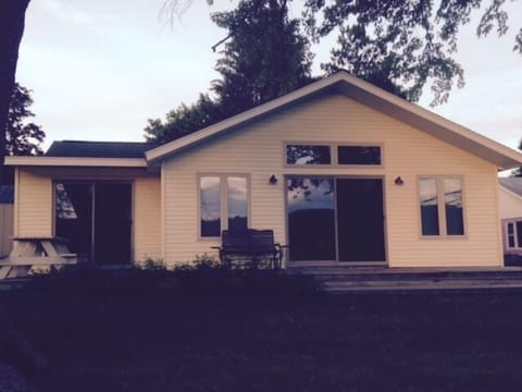 Lake front of the home with deck and picnic table