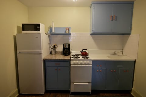 Urban kitchen with gas range, microwave, and efficiency refrigerator.