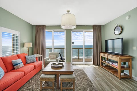 Relax in your bright oceanfront living room with panoramic sea views and comfortable coral sofa.
