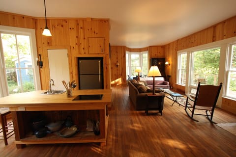 Kitchen extends into the living area in front of house.