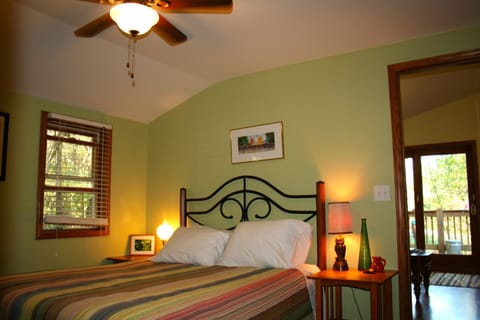The bedroom is furnished with a queen bed, armoire, and comfortable seating.