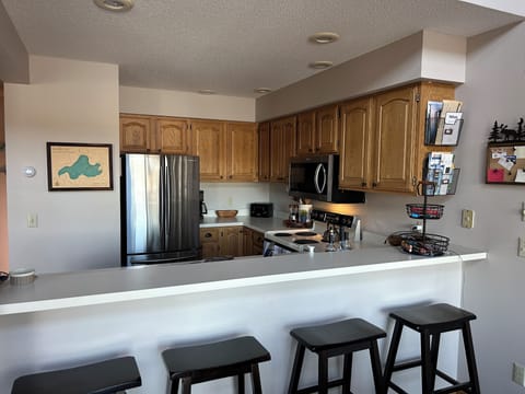 Kitchen + Breakfast bar. Fully stocked kitchen.