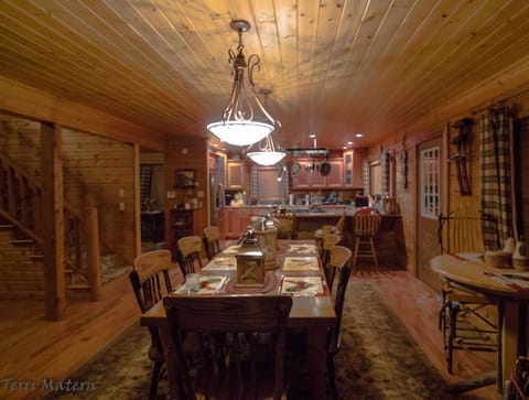 Diningroom with table seating 8 people, kitchen in the background.