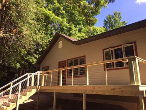 Back of cabin looking out to large backyard/woods and lake